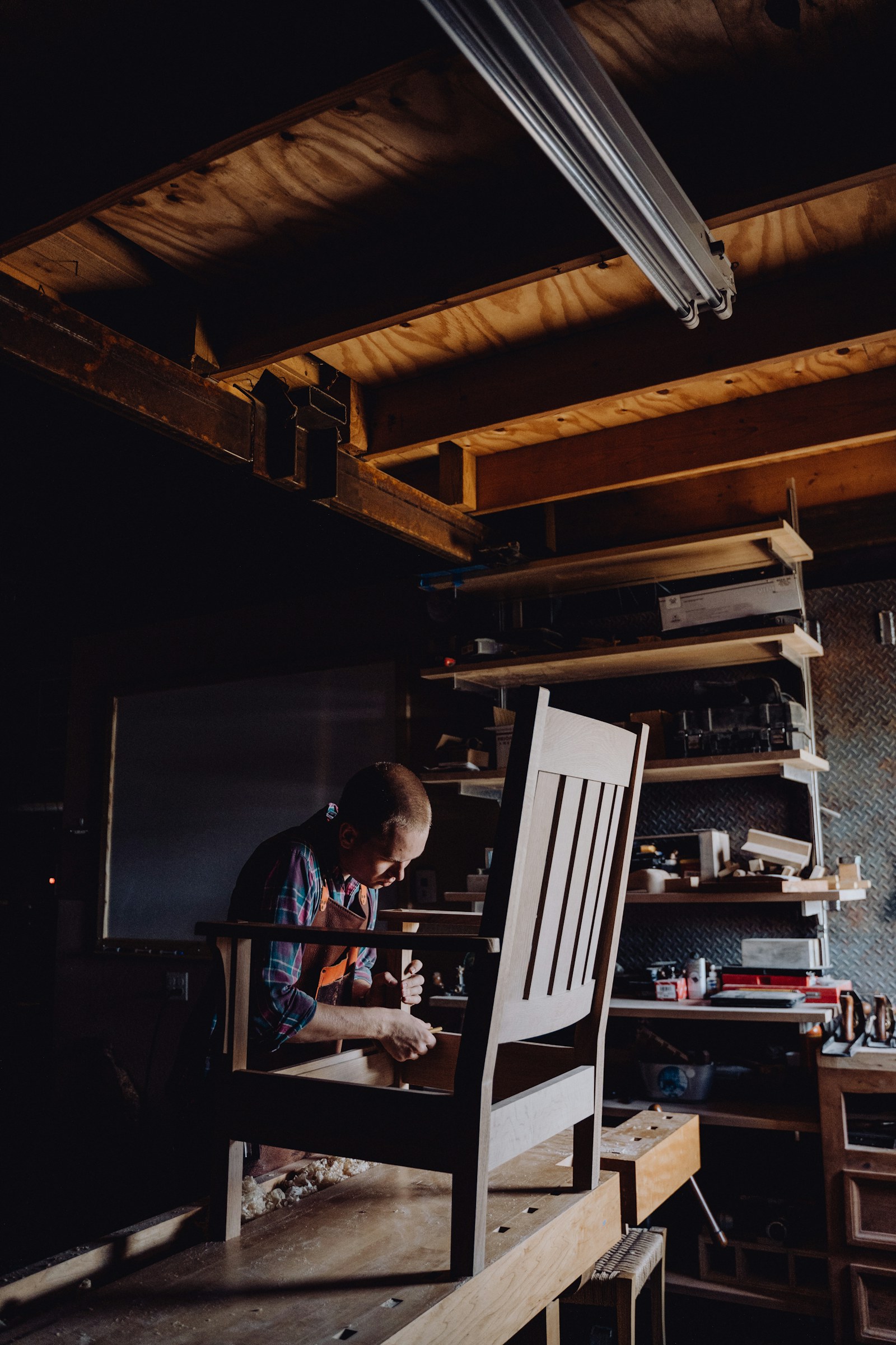 Craftsperson working on a wood chair in a workshop